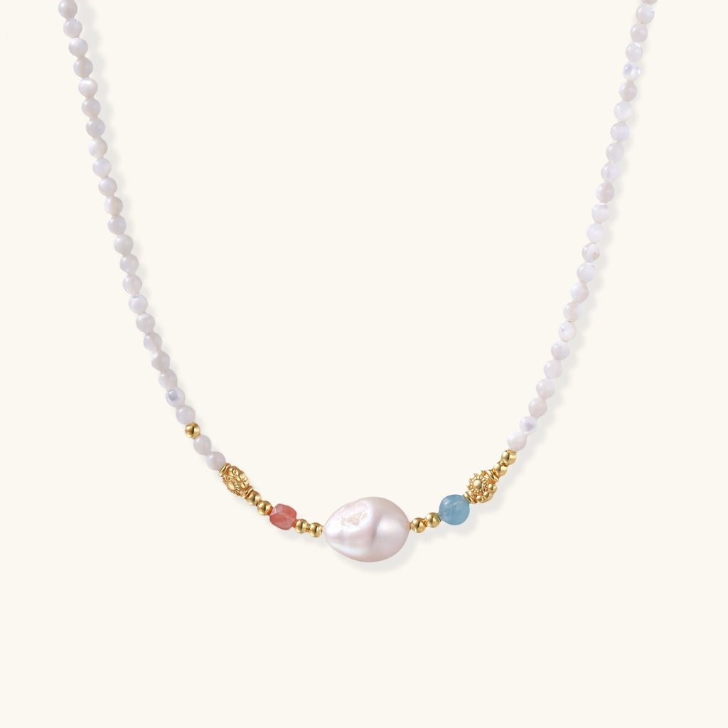 Beaded necklace with small white moonstone beads, central baroque freshwater pearl, coral and blue stone accents, gold floral spacers.