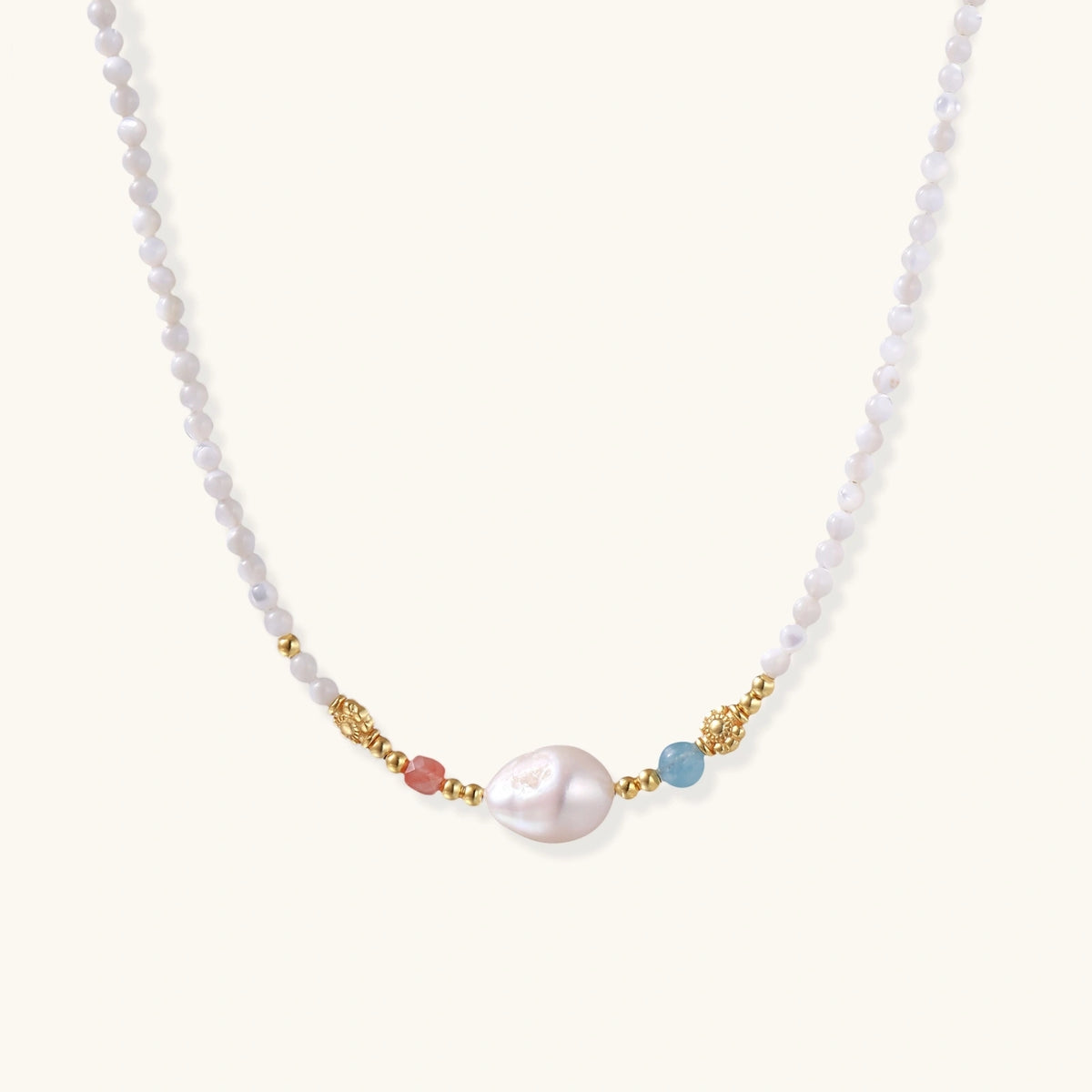 Beaded necklace with small white moonstone beads, central baroque freshwater pearl, coral and blue stone accents, gold floral spacers.