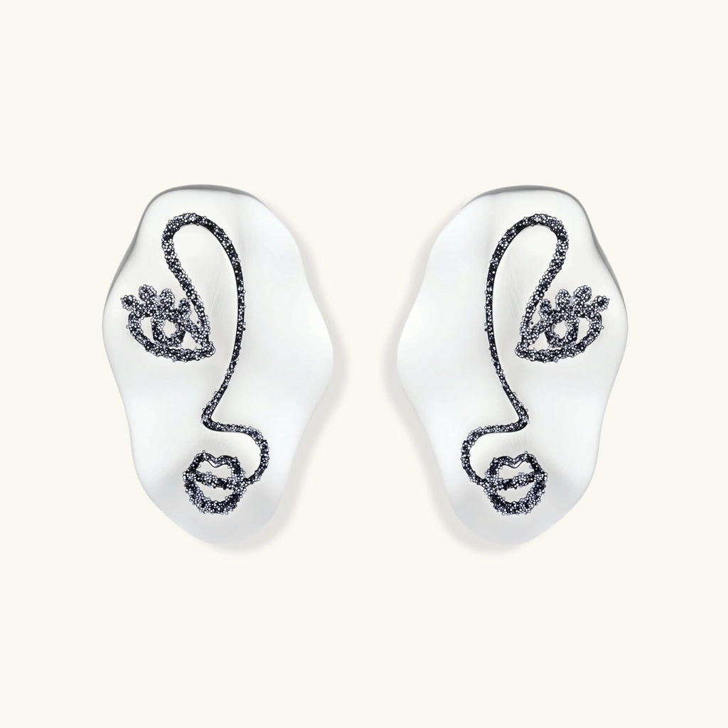 Artistic ear-shaped earrings with minimalist face line art on clear eco-zinc alloy base with sterling silver posts.