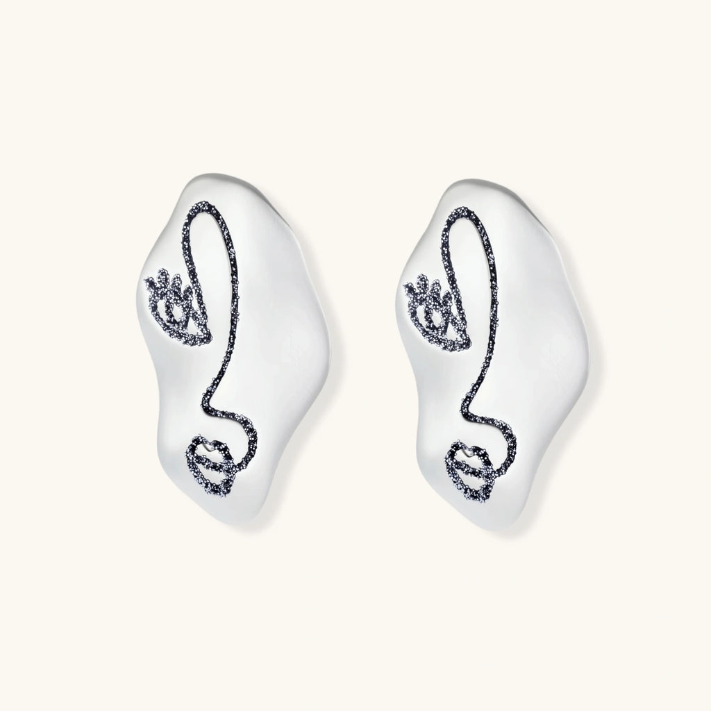Artistic ear-shaped earrings with minimalist face line art on clear eco-zinc alloy base with sterling silver posts.