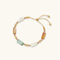Adjustable gold-plated bracelet featuring rectangular shell beads in green, orange, and white tones on cream background.